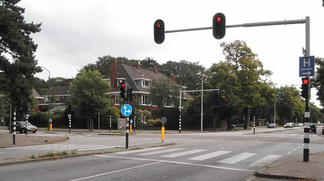 Kruispunt met meerdere verkeerslichten en verkeersborden tegelijk in beeld